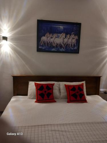 Un dormitorio con una cama con almohadas rojas. en Amith Villa Kabalana, en Koggala