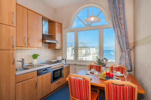 a kitchen with a table with chairs and a window at Villa Sommerfreude in Bansin