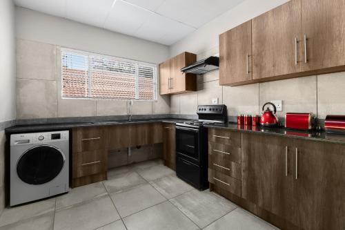 a kitchen with a stove and a dishwasher at Park Hotel Mokopane in Mokopane