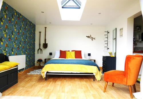 1 dormitorio con 1 cama y 1 silla en Private Garden Room - Rural Village, en Stamford