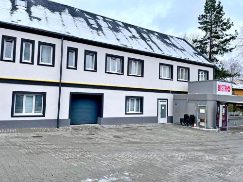 a large white building with a blue garage at Apartments Gato Karlovy Vary Stara Role in Karlovy Vary