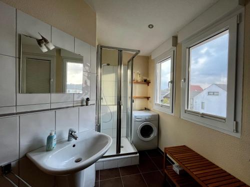 a bathroom with a sink and a washing machine at Ferienhaus Strandräuber in Zierow