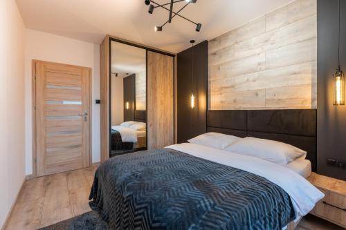 Vip Apartament z klimatyzacją Lubelska في جيشوف: غرفة نوم بسرير كبير ومرآة