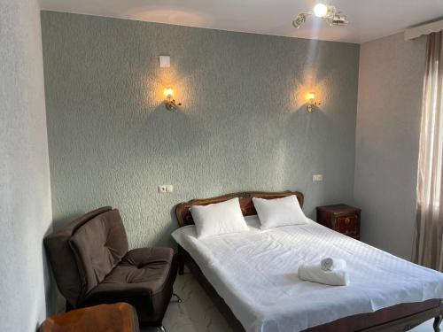 a bedroom with a bed and a chair at Amfitrita Hotel Ureki in Ureki