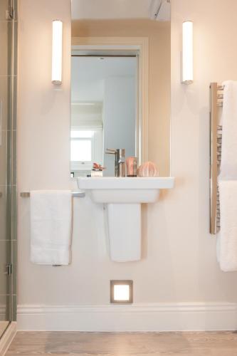 a bathroom with a sink and a mirror at The Charm Brighton Boutique Hotel & Spa in Brighton & Hove