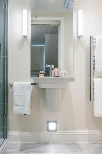 a bathroom with a sink and a mirror at The Charm Brighton Boutique Hotel & Spa in Brighton & Hove