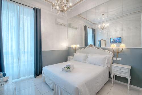 Un dormitorio con una cama blanca con un osito de peluche. en Home Grifondoro Affittacamere, en Génova