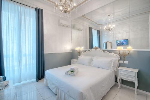 a bedroom with a white bed with a teddy bear on it at Home Grifondoro Affittacamere in Genoa