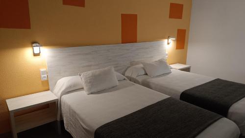 a hotel room with two beds and two lamps at Hotel Venta de la Punta in Santa Bárbara