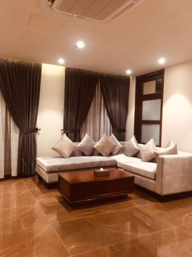 a living room with a couch and a coffee table at Jacaranda Heights in Islamabad