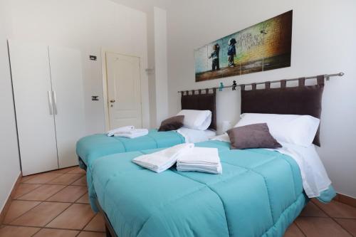 2 camas en una habitación con sábanas azules en La casa di Jacopo [Intero appartamento+parcheggio], en Pistoia