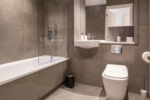 łazienka z toaletą, umywalką i wanną w obiekcie Prestige Apartment w Birmingham