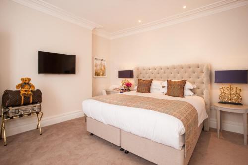 a bedroom with a large bed and a flat screen tv at The Charm Brighton Boutique Hotel & Spa in Brighton & Hove