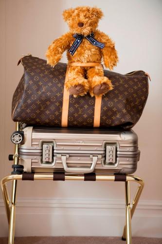 a teddy bear sitting on top of a pile of luggage at The Charm Brighton Boutique Hotel & Spa in Brighton & Hove
