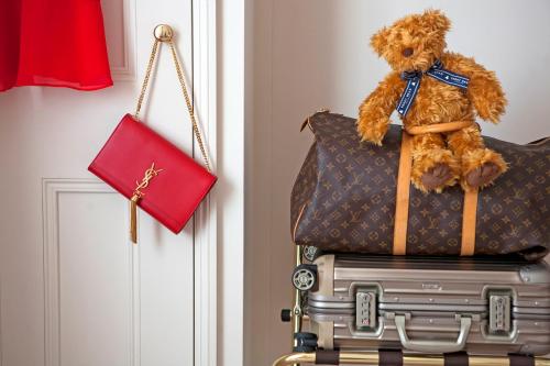 a teddy bear sitting on top of a pile of luggage at The Charm Brighton Boutique Hotel & Spa in Brighton & Hove