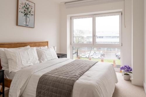 sypialnia z dużym łóżkiem i dużym oknem w obiekcie Prestige Apartment w Birmingham