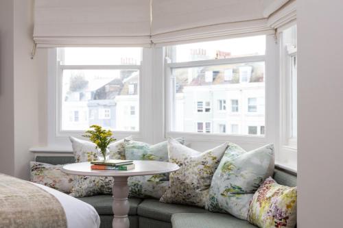 a living room with a couch with pillows and a table at The Charm Brighton Boutique Hotel & Spa in Brighton & Hove