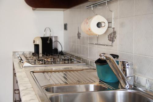 encimera de cocina con fregadero y fogones en La casa di Jacopo [Intero appartamento+parcheggio], en Pistoia
