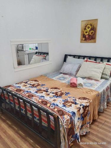 a bed in a bedroom with a blanket on it at 8 JOAQUIN'S Place WIFI Free! in Antipolo