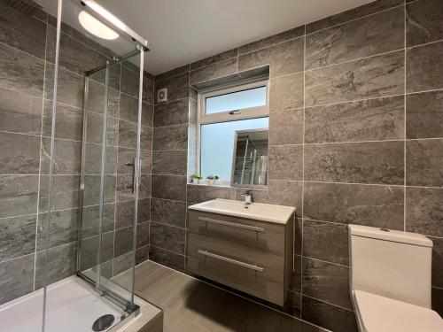 ein Bad mit einer Dusche, einem WC und einem Waschbecken in der Unterkunft Immaculate Newly Refurbished 4 Bed House in Nottingham
