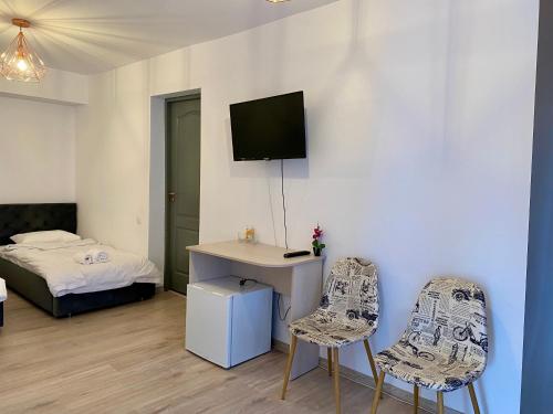 a room with two chairs and a desk and a bed at InnTime in Cluj-Napoca