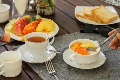 a table with two cups of tea and plates of food at VODA Hotel in Galle