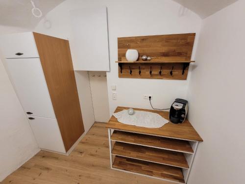 eine kleine Küche mit weißen Wänden und Holzregalen in der Unterkunft Ferienwohnung Am Schlossberg in Bad Sankt Leonhard im Lavanttal
