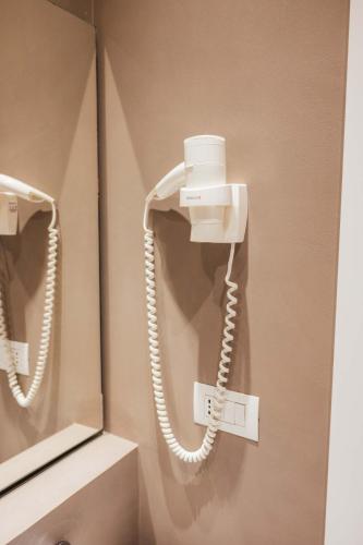 a phone on a wall next to a mirror at Al Pescatore - B&B in Bari