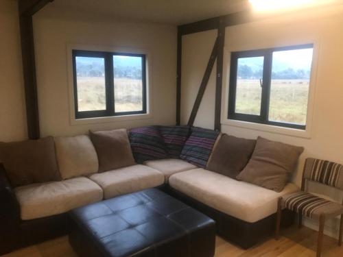 ein Wohnzimmer mit einem Sofa und 2 Fenstern in der Unterkunft The Bunkhouse at camp Infinite 