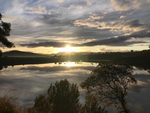 un reflejo del sol en un lago en The Bunkhouse at camp Infinite, 