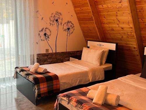 a bedroom with two beds and a window at Qafqaz Mountain Chalet in Gabala