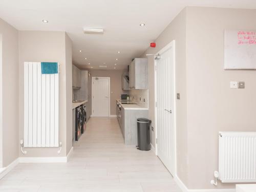 a kitchen with white walls and a white floor at Pass the Keys Burnley Central Hub Stylish Stay in Burnley