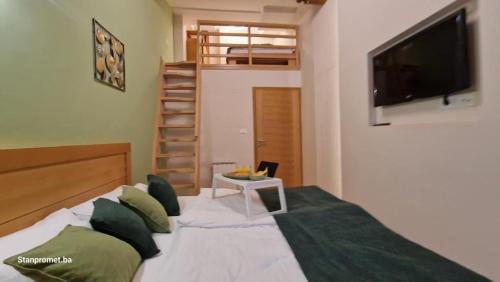 a bedroom with a bed with a flat screen tv at Apartman 109 LUX - Aparthotel Vucko Jahorina private host in Jahorina