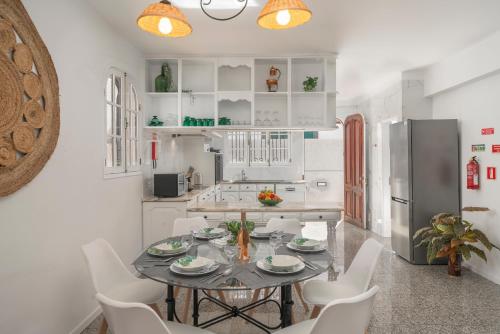 a kitchen with a table and chairs and a refrigerator at OurMadeira - BelleVeva in Funchal