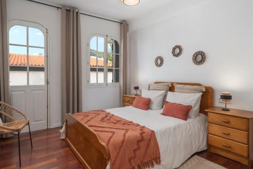 a bedroom with a bed and two windows at OurMadeira - BelleVeva in Funchal