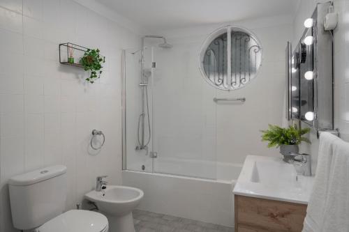 a white bathroom with a toilet and a sink at OurMadeira - BelleVeva in Funchal