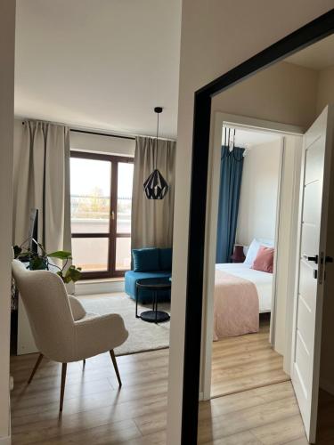 a bedroom with a bed and a chair and a mirror at TS New Town Top Apartment in Szczecin