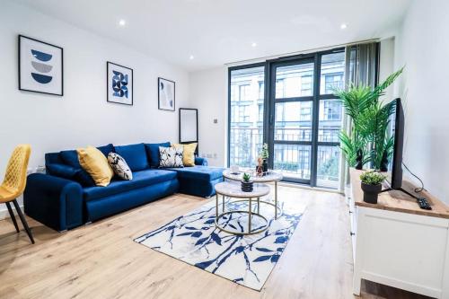 a living room with a blue couch and a table at Canary Wharf-10% discount-Fibre Wifi-5mins to Tube in London