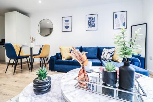 a living room with a blue couch and a table at Canary Wharf-10% discount-Fibre Wifi-5mins to Tube in London