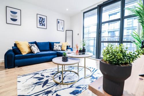 a living room with a blue couch and a table at Canary Wharf-10% discount-Fibre Wifi-5mins to Tube in London