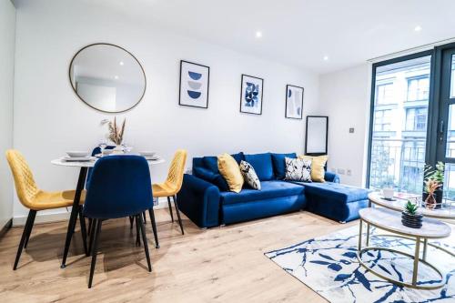 a living room with a blue couch and a table at Canary Wharf-10% discount-Fibre Wifi-5mins to Tube in London