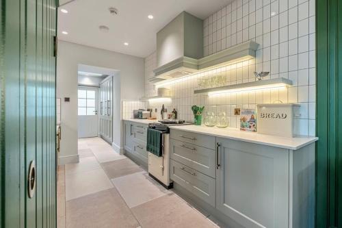 a large kitchen with white cabinets and a stove at Luxury Mews House in Harrogate in Harrogate