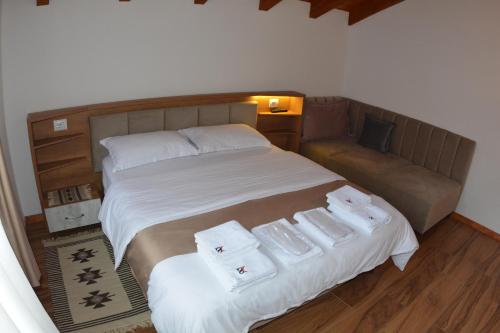 a bedroom with a bed with two white towels on it at Sofra Kelmendit in Tamarë
