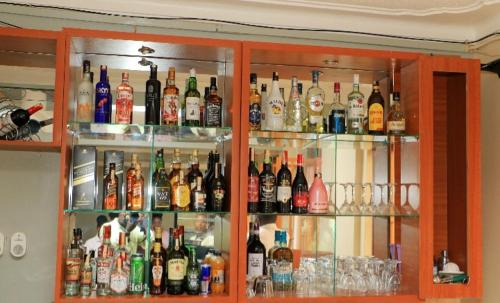 PRIMEROSE HOTEL في Mubende: خزانة مليئة بالكثير من زجاجات الكحول
