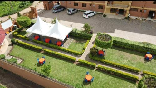PRIMEROSE HOTEL في Mubende: اطلالة جوية على حديقة فيها خيمة بيضاء