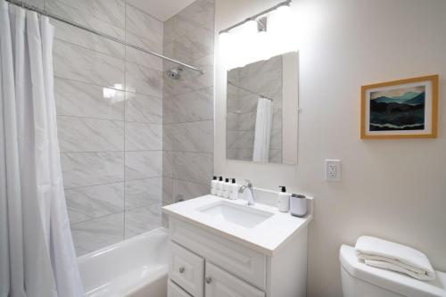 a white bathroom with a sink and a shower at Dupont Circle 1br w wd nr bars metro station WDC-750 in Washington, D.C.