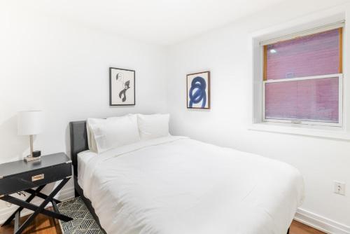 a white bedroom with a bed and a window at Logan Circle 1br w wd nr park dining WDC-755 in Washington, D.C.