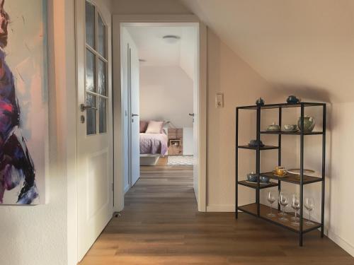 einen Flur mit einem Zimmer mit einer Treppe und einem Zimmer mit einem Bett in der Unterkunft Roof Lounge in Südbrookmerland