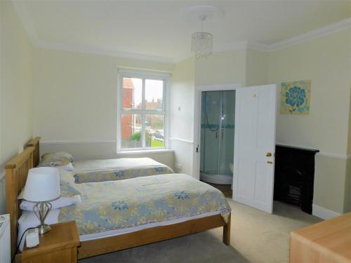 a bedroom with a bed and a window at Corner House in Sheringham