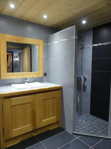 a bathroom with a sink and a shower with a mirror at Auberge des églantiers in Flumet